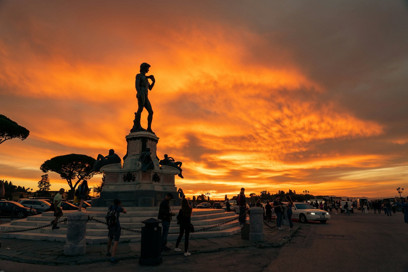The bronze David at Piazzale Michelangelo against an orange sunset sky